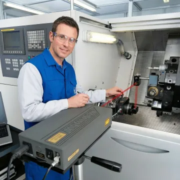 Precision CNC machining center undergoing laser interferometer calibration with measurement equipment