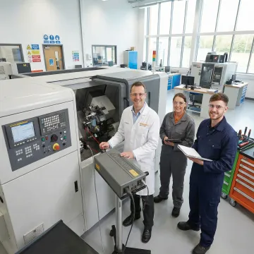 CNC machine maintenance training session with technician demonstrating calibration equipment