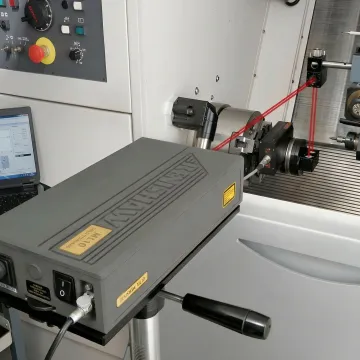 Close-up of laser interferometer measuring linear axis movement on precision CNC machine