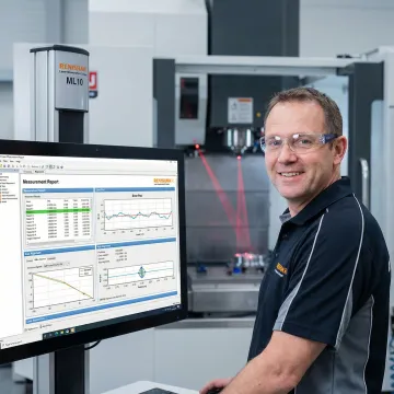 Calibration specialist analyzing CNC machine measurement data on laptop