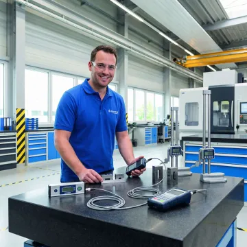 Technician measuring surface plate flatness with precision equipment