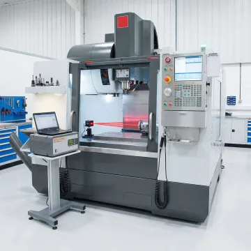 CNC machine undergoing precision laser calibration testing in manufacturing facility