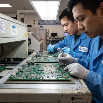 Coated PCB assemblies undergoing inspection