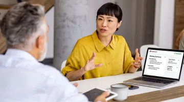 Financial adviser using AI-powered client meeting tool on laptop in modern office