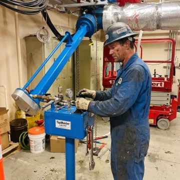 Technician operating pipeline line stop equipment