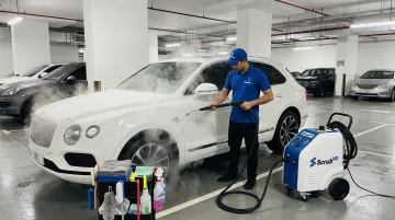 ScrubUp mobile steam wash technician servicing car in Dubai parking area