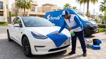 Mobile detailing technician performing eco-friendly car wash in Dubai parking lot