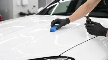 Detailer applying ceramic coating to car surface during proper prep process