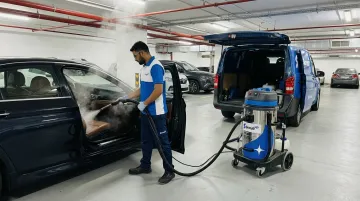ScrubUp mobile car cleaning technician performing steam treatment in residential parking