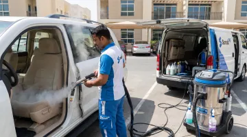 ScrubUp technician performing mobile steam cleaning on car interior
