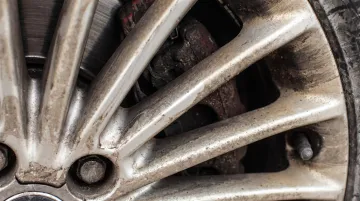 Dusty uncoated car wheel with baked-on brake dust residue