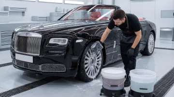 Detailer using two-bucket method on luxury ceramic-coated car