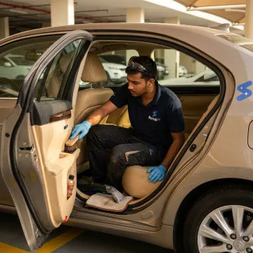 Technician cleaning leather car seat