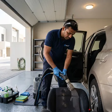 Technician deep-cleaning a car seat in Dubai