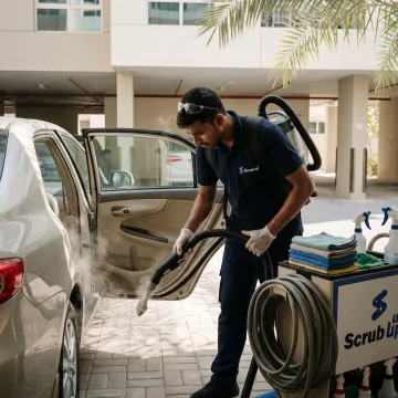 Technician detailing a car interior at a parking spot