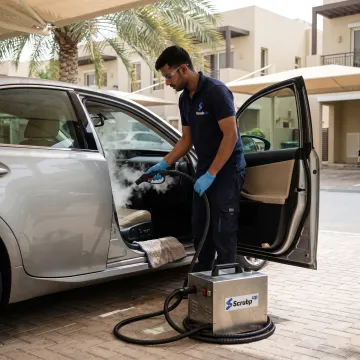 Technician steam-cleaning a car interior