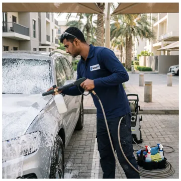 Technician cleaning a car at a Dubai parking space