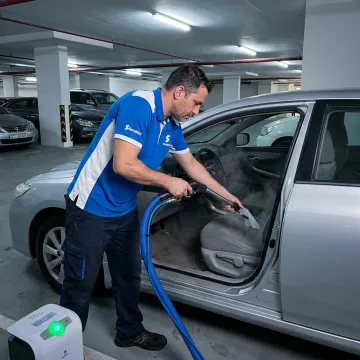 Technician cleaning car interior for odor removal