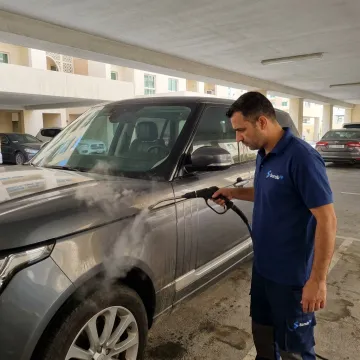 Mobile steam cleaning a car in Dubai parking