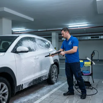 Mobile car wash technician cleaning vehicle