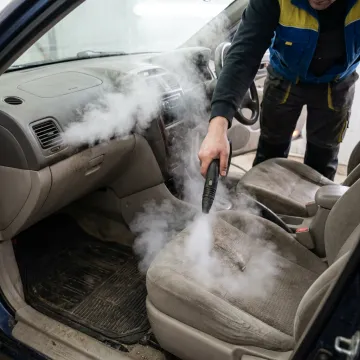 Steam nozzle cleaning a car interior