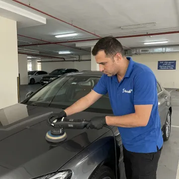 Technician machine polishing a car hood