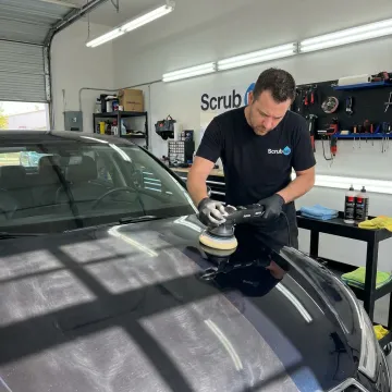 Technician polishing car paint