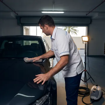 Technician polishing car paint