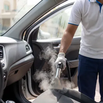 Steam nozzle cleaning a car interior