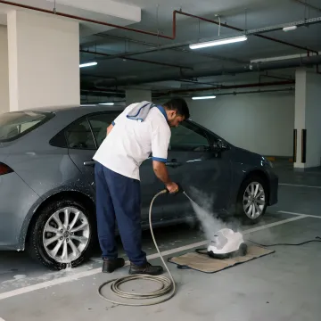 Mobile car wash technician cleaning a car in Dubai parking