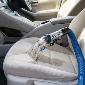 Upholstery extractor cleaning a vehicle seat