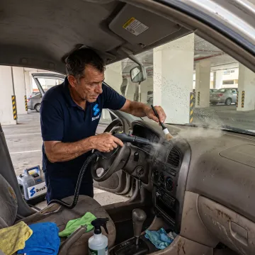 Mobile technician detailing a car interior