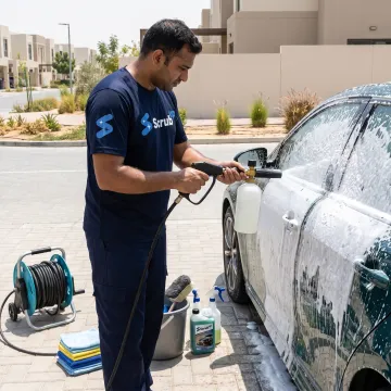 Mobile technician cleaning a car in a parking area