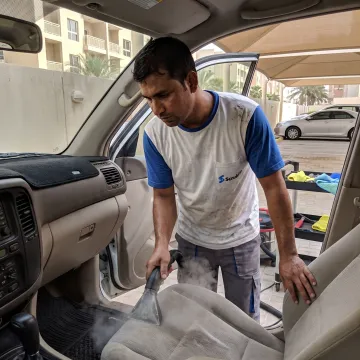 Mobile technician detailing a car interior