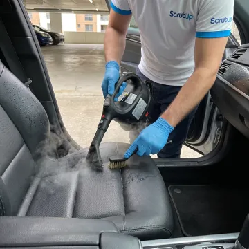 Mobile technician detailing a clean car interior