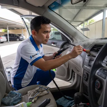 Technician detailing a car interior at home