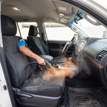 Technician deodorising a car interior