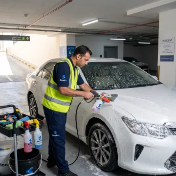 Mobile technician cleaning a car at a parking space