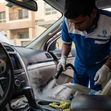 Technician deep cleaning a car interior in Dubai