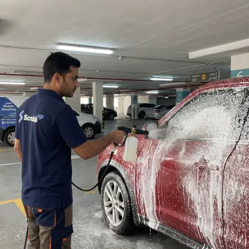 Technician professionally cleaning a car exterior