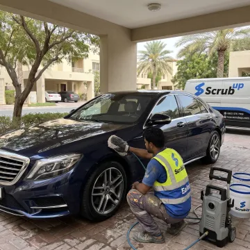 Mobile technician cleaning a luxury car in Dubai