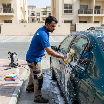 Technician detailing a car at a Dubai parking space