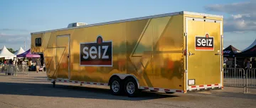 Event marketing trailer with glossy gold vinyl wrap