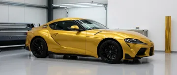 Personal car with glossy metallic gold color-change vinyl wrap