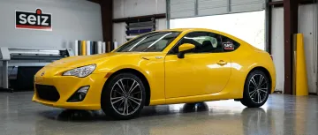 Personal car with yellow vinyl color-change wrap