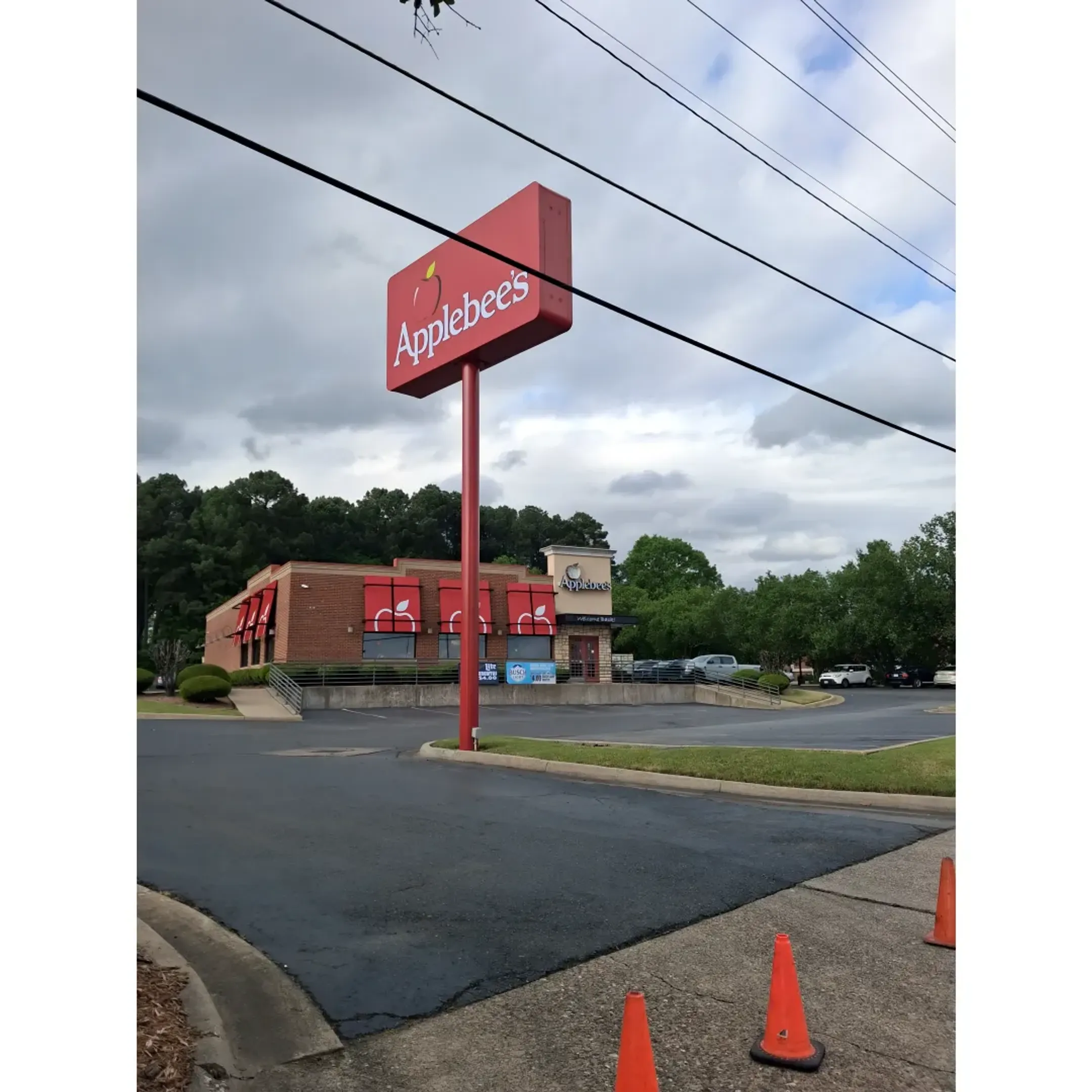 Professional team installing a large illuminated channel letter sign for a national franchise on a commercial building.