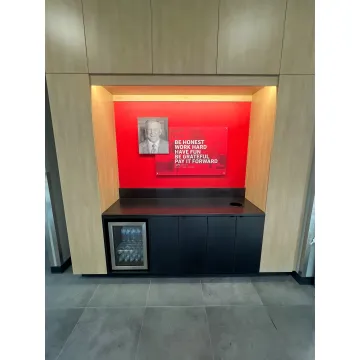 A sign technician carefully installing a custom office sign.