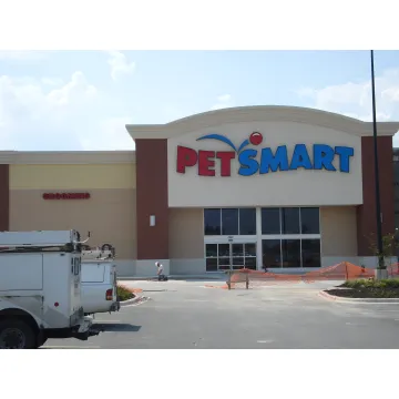 Professional technicians installing a large commercial sign on a building facade in North Little Rock.