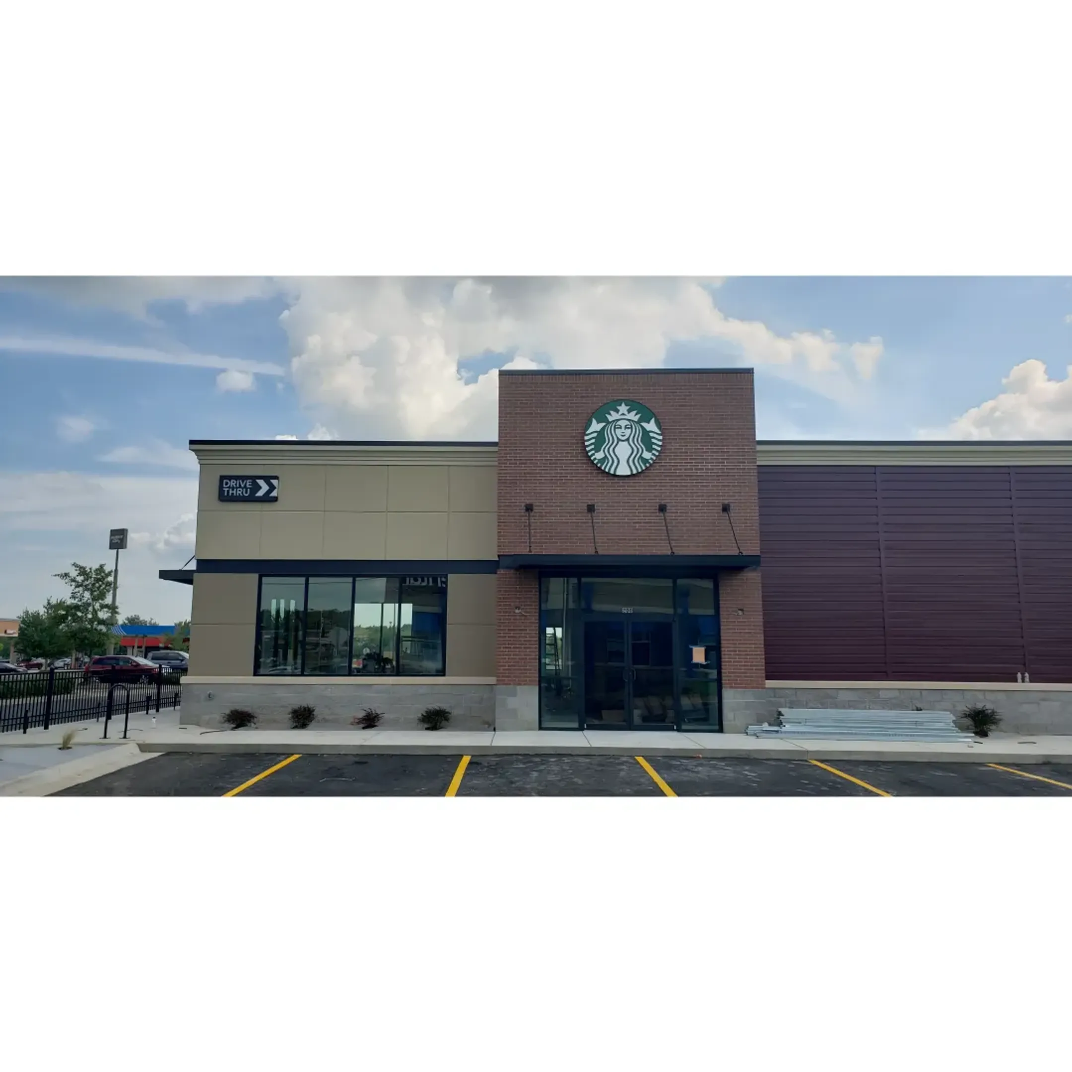 Custom fabricated metal sign being installed on a modern building exterior.