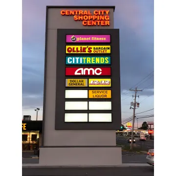 A professional team installing a large commercial sign on a modern building facade.